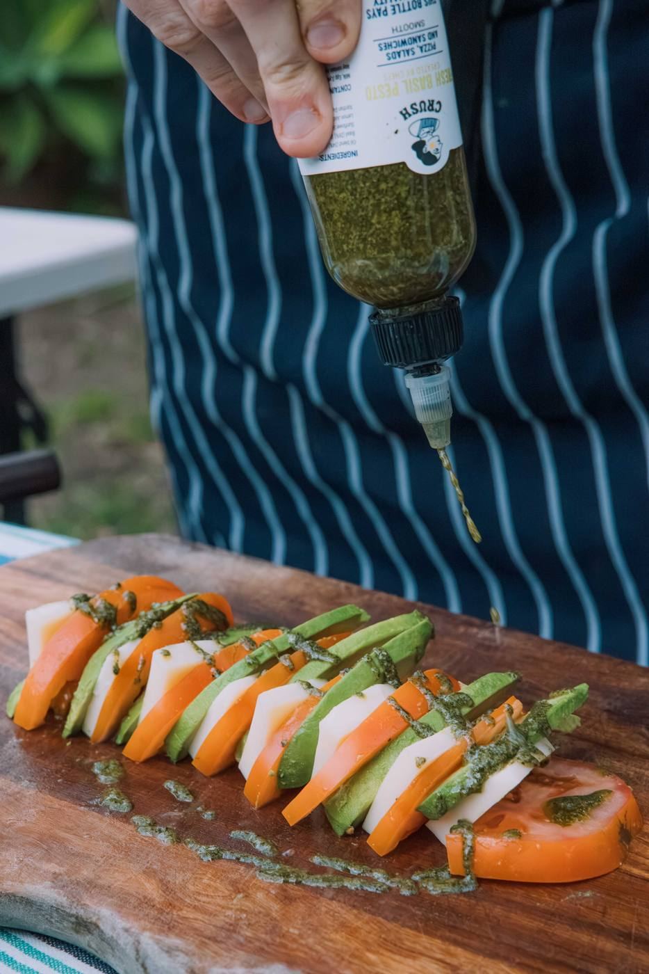 Pesto dressing tomato and mozzarella on a wooden board